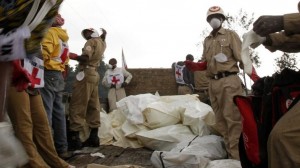Red Cross workers collect bodies in body bags to load onto a truck in Ndosho near Goma