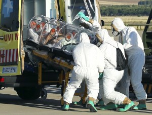 Health workers load Ebola patient, Spanish priest Miguel Pajares, into an ambulance on the tarmac of Torrejon airbase in Madrid