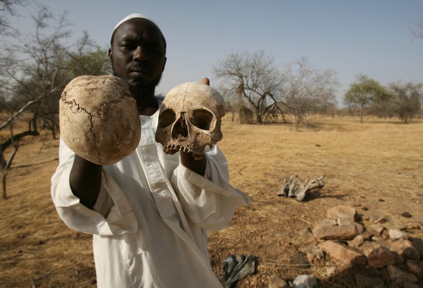 ** FILE ** In this Monday, April 23, 2007 file photo, Sudanese Darfur survivor Ibrahim holds human skulls at the site of a mass grave where he says the remains of 25 of his friends and fellow villagers lie, on the outskirts of the West Darfur town of Mukjar, Sudan. The International Criminal Court issued an arrest warrant Wednesday, March 4, 2009 for Sudanese President Omar al-Bashir on charges of war crimes and crimes against humanity in Darfur. (AP Photo/Nasser Nasser, File)