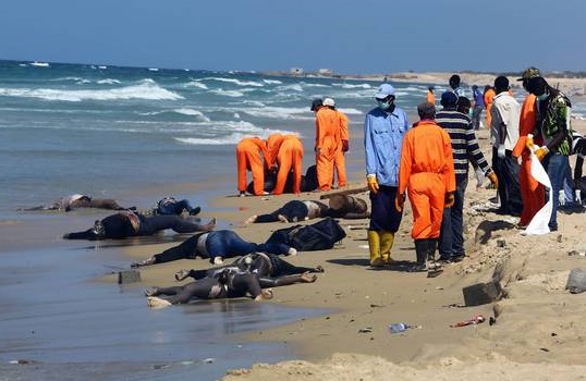 Rescuers collect the bodies of African would-be migrants that were washed up on the shore of al-Qarboli, some 60 kilometers east of Tripoli, Libya, 25 August 2014. More than 220 migrants were reported dead on 25 August following three shipwrecks at the weekend off the coasts of Libya and Italy. Libyan navy spokesman Ayoub Abul Qassem said that least 200 people died in a shipwreck on 22 August, adding that the search was on for the missing. The wooden boat was carrying African migrants and only 17 had survived so far. ANSA/STR ATTENTION EDITORS: PICTURE CONTAINS GRAPHIC CONTENT