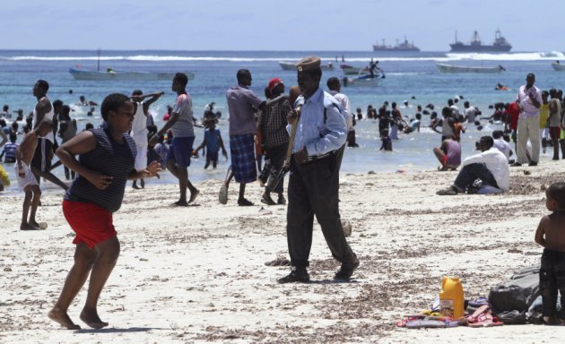 A police officer patrols as residents swim in the Indian Ocean waters near Lido beach, north of Somalia's capital Mogadishu, October 19, 2012. Lido beach was a famous attraction before Somalia tumbled into chaos in 1991 with the ousting of dictator Mohamed Siad Barre. In the last few years, the beach was a frontline for the Islamist al Shabaab militants, who later withdrew from most parts of Mogadishu. (REUTERS/Feisal Omar)