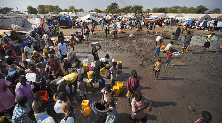 FILE - In this Sunday, Dec. 29 2013 file photo, displaced people gather around a water truck to fill containers, at a United Nations compound which has become home to thousands of people displaced by the recent fighting, in the capital Juba, South Suda. Sudan's political limbo continued Friday, Aug. 19, 2016 after rebel leader Riek Machar fled the country earlier in the week. Last month government and rebel forces clashed in the capital, killing hundreds of civilians and Machar was controversially removed as First Vice President. Machar's departure puts South Sudan's peace deal into disarray at the same time the country is suffering from a humanitarian crisis. (AP Photo/Ben Curtis,file)