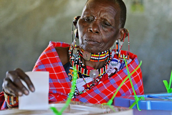 Una signora masai depone la sua scheda nell’urna elettorale (AFP)
