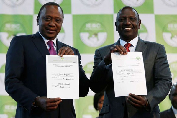 Uhuru Kenyatta e il suo vice William Ruto mostrano i certificati che li confermano nelle rispettive cariche 