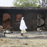 A woman walks past burnt houses in the aftermath of what Nigerian authorities said was heavy fighting between security forces and Islamist militants in Baga