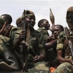 M-23 rebel fighters ride in a truck as they withdraw from Goma
