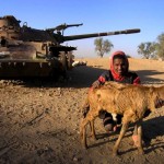 A man from Badme poses in front of a tank abandoned during the 1998-200 border war with Ethiopia in Eritrea