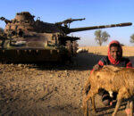 A man from Badme poses in front of a tank abandoned during the 1998-200 border war with Ethiopia in Eritrea