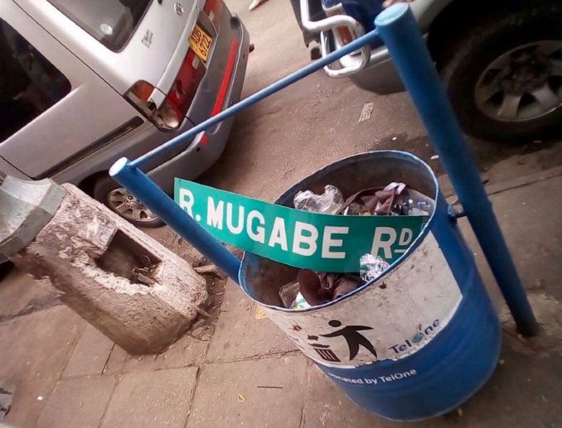 La targa della strada che porta il nome di Mugabe buttata nella spazzatura