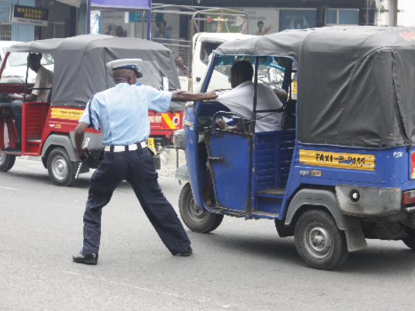 Agente del traffico alle prese con il conducente di un tuk-tuk che cerca di scappare