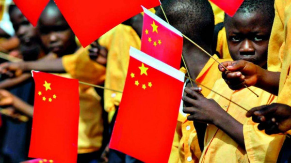 Bimbi tanzaniani sventolano bandierine cinesi di benvenuto al loro partner orientale