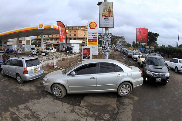 Coda di autoveicoli a una stazione di servizio nell'imminenza dell'aumento del costo carburante