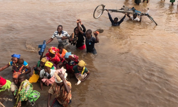 Chimoio, Mozambico. Persone si affrettano ad attraversare un fiume per andare alla prima distribuzione di cibo più di due mesi dopo il ciclone. (Foto © courtesy Devon Cone, Refugees International)