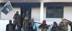 Isis-Mozambico Jihadisti armati con la bandiera dello Stato islamico davanti alla caserma di polizia di Quissanga