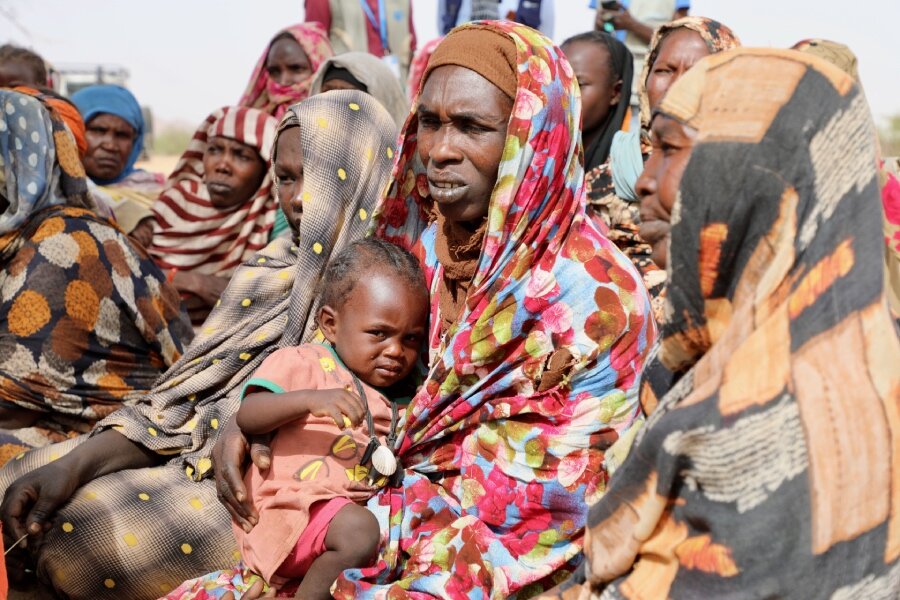 Aicha Madar (C) and her daughter Fatima fled to Chad afer she says armed men burned her village in Sudan. Jacques David
