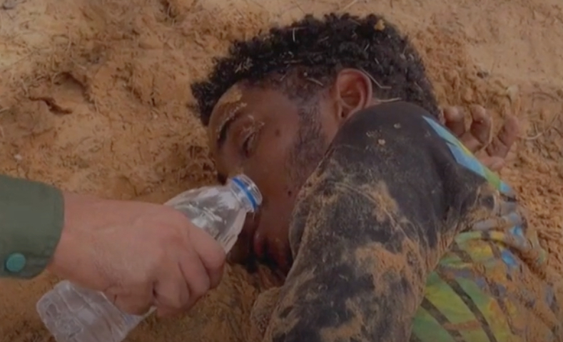 migrante sfinito nel deserto tra Tunisia e Libia